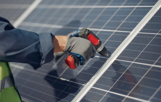 man-with-white-helmet-near-solar-panel